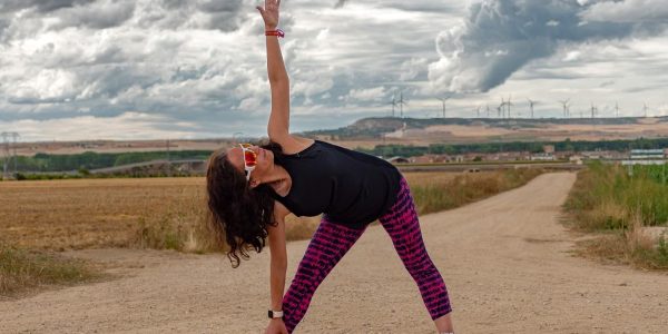 Outdoor fitness scene of a woman stretching on a dirt path in Soto de Cerrato amidst scenic landscapes.